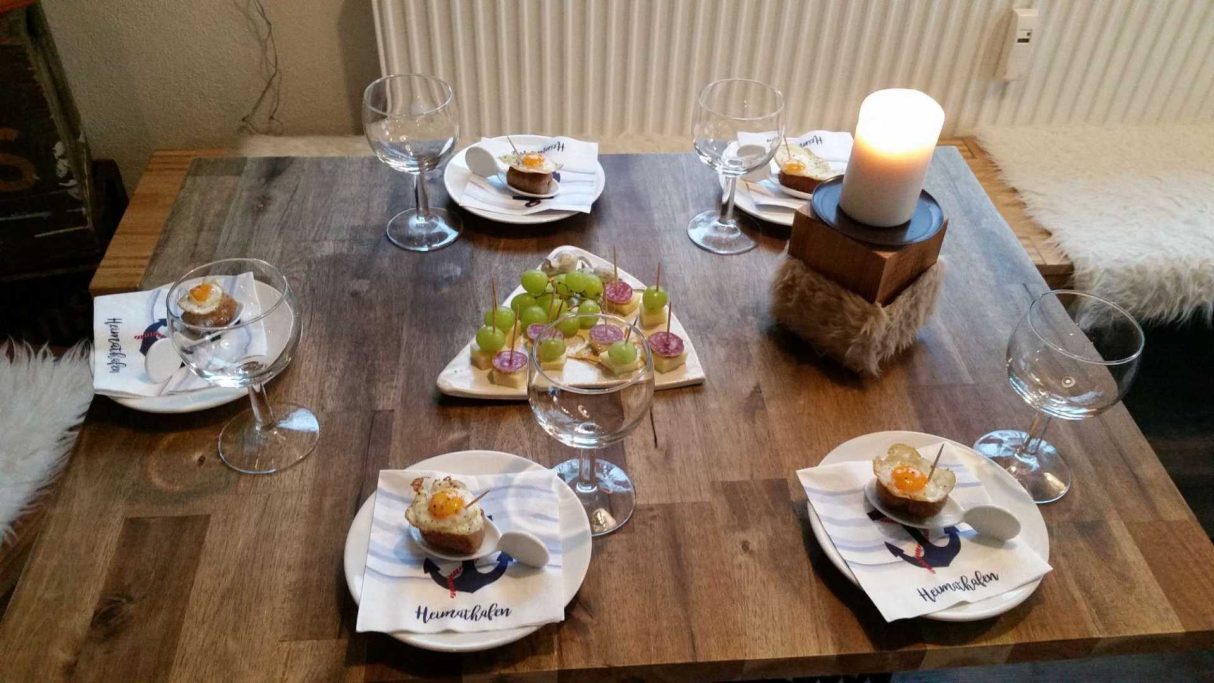 Elegant gedeckter Tisch mit Dessert, frischen Trauben und Kerze.