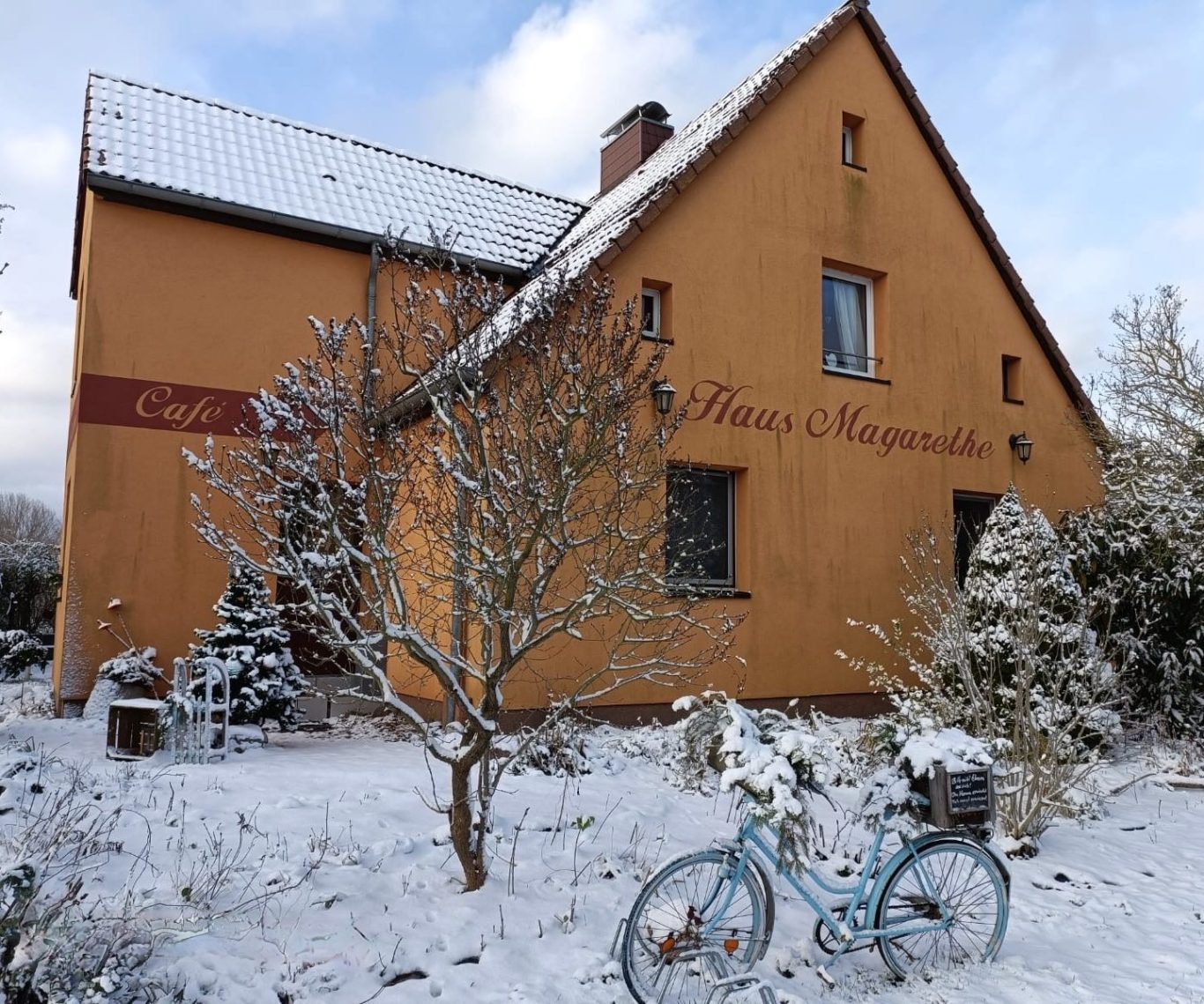 Fassade eines Hauses mit der Aufschrift "Haus Magarethe" in pinken Farbtönen.