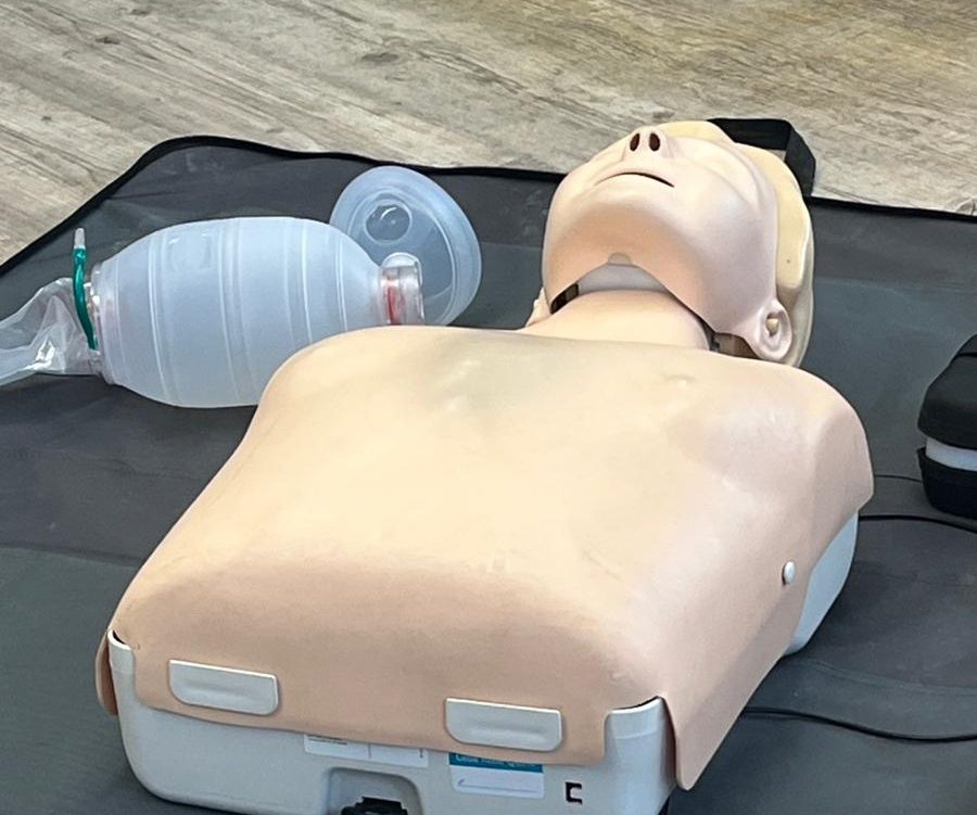 Ein CPR-Trainer mit Atembeutel auf einer Übungsunterlage.
