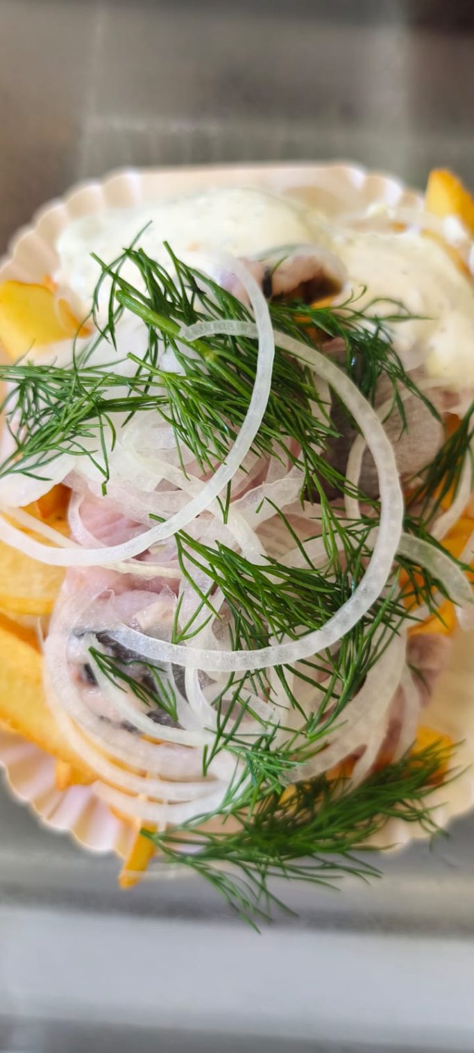 Pommes mit Zwiebeln, Dill und einer cremigen Sauce serviert in einer Schale.