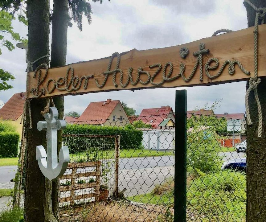 Holzschild mit der Aufschrift "Poeler Auszeiten" und einem Anker darunter.