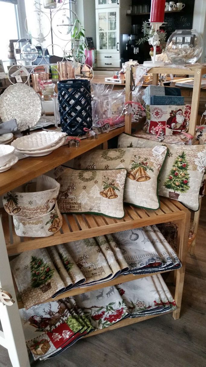 Dekorierte Tischtücher, Kissen und Geschirr in einem einladenden Verkaufsbereich.