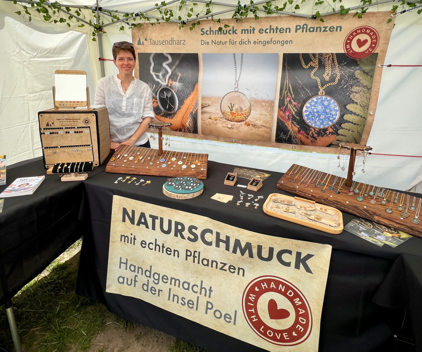 Marktstand mit Schmuck aus Pflanzen. Verkäuferin präsentiert handmade Produkte.