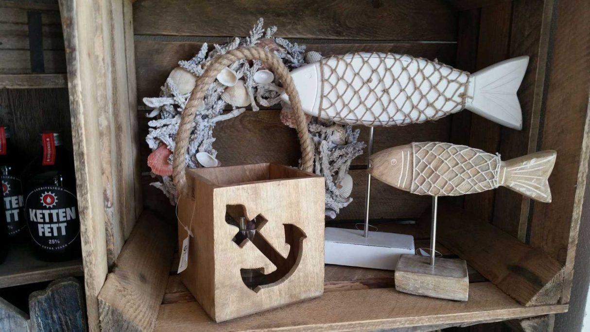Ein Holzkorb mit Anker, dekorative Fische und ein Kranz in einem Kistenset.