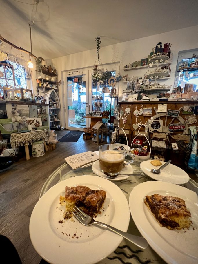 Gemütliche Caféatmosphäre mit Kuchenstücken und Kaffee auf einem Tisch.